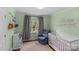 Charming bedroom with soft green walls, stylish decor, and a comfortable rocking chair and crib at 6127 Rosecrest Dr, Charlotte, NC 28210