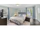 Tranquil bedroom with a comfortable queen bed, soft blue curtains, and plenty of natural light at 6127 Rosecrest Dr, Charlotte, NC 28210