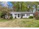 Charming white-brick ranch-style home with a well-manicured lawn and mature trees, offering classic curb appeal at 6127 Rosecrest Dr, Charlotte, NC 28210