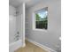 Bathroom features neutral tile floors, shower with tub, and a window for natural light at 6204 River Birch Dr, Gastonia, NC 28056