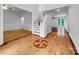 Bright foyer with hardwood floors, decorative inlay, staircase, and views into other living spaces at 6204 River Birch Dr, Gastonia, NC 28056