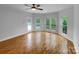 Sun-filled living room with hardwood floors and large windows offering scenic backyard views at 6204 River Birch Dr, Gastonia, NC 28056