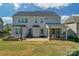 Back exterior of the house featuring a brick patio, outdoor seating, and screened porch at 8008 Hudson Mill Dr, Waxhaw, NC 28173