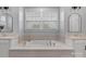 Elegant bathroom with a soaking tub, dual vanities, and large mirrors reflecting natural light at 8008 Hudson Mill Dr, Waxhaw, NC 28173