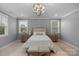 Well-lit bedroom featuring neutral walls, decorative lighting, and side tables with lamps at 8008 Hudson Mill Dr, Waxhaw, NC 28173