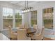 Breakfast nook with round wood table, upholstered chairs, large windows, and decorative chandelier at 8008 Hudson Mill Dr, Waxhaw, NC 28173