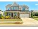 Charming two-story home featuring a stone and siding facade, attached two car garage, and well-manicured lawn at 8008 Hudson Mill Dr, Waxhaw, NC 28173