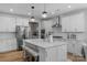 Bright kitchen features white cabinets, stainless steel appliances, large center island, and hardwood floors at 8008 Hudson Mill Dr, Waxhaw, NC 28173