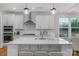 Bright kitchen features white cabinets, stainless steel appliances, large center island, and modern pendant lighting at 8008 Hudson Mill Dr, Waxhaw, NC 28173