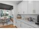 Bright, open kitchen featuring white cabinets, quartz countertops, and hardwood floors that lead to dining area at 8008 Hudson Mill Dr, Waxhaw, NC 28173