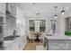 Open kitchen featuring stainless appliances, white cabinets, an island, and hardwood floors adjacent to the breakfast nook at 8008 Hudson Mill Dr, Waxhaw, NC 28173
