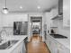 Gourmet kitchen with stainless steel appliances, white cabinetry, quartz countertops, and hardwood floors at 8008 Hudson Mill Dr, Waxhaw, NC 28173