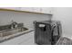 This laundry room is equipped with granite countertops, sink, and a black washer and dryer at 8008 Hudson Mill Dr, Waxhaw, NC 28173