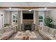 Bright living room featuring hardwood floors, exposed wood beams, fireplace with mantel, and stylish neutral furnishings at 8008 Hudson Mill Dr, Waxhaw, NC 28173