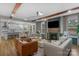 A bright living room featuring hardwood floors, exposed wood beams, fireplace with mantel, and stylish neutral furnishings at 8008 Hudson Mill Dr, Waxhaw, NC 28173