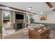 Bright living room featuring hardwood floors, exposed wood beams, fireplace with mantel, and stylish neutral furnishings at 8008 Hudson Mill Dr, Waxhaw, NC 28173