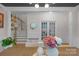 Bright dining room with view of the staircase and office behind french doors, featuring neutral walls and wood floors at 8008 Hudson Mill Dr, Waxhaw, NC 28173