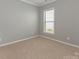 Cozy bedroom with neutral walls, carpet flooring, and a bright window, providing a serene and comfortable atmosphere at 804 Birdsong Way, Fort Mill, SC 29715