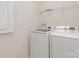 Practical laundry room featuring modern, white front load washer and dryer, with storage shelf above at 804 Birdsong Way, Fort Mill, SC 29715