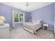 Bedroom features a ceiling fan, a large window, and a bed with white frame and pink flowered bedding at 8517 Sandowne Ln, Huntersville, NC 28078