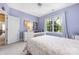 Bedroom features a ceiling fan, a large window, and a bed with white frame and flowered bedding at 8517 Sandowne Ln, Huntersville, NC 28078
