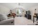 Bonus room features a ceiling fan, a window with curtains, TV, comfortable furniture, and neutral carpeting at 8517 Sandowne Ln, Huntersville, NC 28078