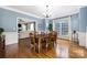 Formal dining room with hardwood floors, chandelier, and plenty of natural light, open to the living area at 8517 Sandowne Ln, Huntersville, NC 28078