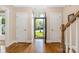 Inviting foyer featuring hardwood floors, white trim, and a view to the outdoors through an arched doorway at 8517 Sandowne Ln, Huntersville, NC 28078
