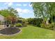 Green backyard featuring a meticulously manicured lawn, garden area, and privacy-enhancing landscaping, creating a serene outdoor space at 879 Knightsbridge Rd, Fort Mill, SC 29708