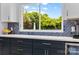 Close-up of kitchen area with blue backsplash and view of lush greenery outside the window at 879 Knightsbridge Rd, Fort Mill, SC 29708