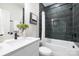 Modern bathroom featuring dark tiled shower-tub, white vanity, and sleek fixtures at 8937 Penstemons Dr, Charlotte, NC 28215