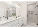 Elegant bathroom featuring double sink vanity, quartz countertop, framed mirror, and glass-enclosed shower at 8937 Penstemons Dr, Charlotte, NC 28215