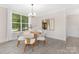 Bright dining area with hardwood floors, modern chandelier, and large windows at 8937 Penstemons Dr, Charlotte, NC 28215