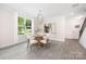 Bright dining area with a modern chandelier, round table, and large windows with natural light at 8937 Penstemons Dr, Charlotte, NC 28215