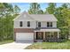 Charming two-story home with a brick facade, attached garage, and a well-manicured front lawn at 8937 Penstemons Dr, Charlotte, NC 28215