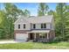 Inviting two-story home featuring brick and siding, a well-kept lawn, and an attached garage at 8937 Penstemons Dr, Charlotte, NC 28215