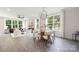 Open-concept space with modern light fixture, dining table, and living area with large windows at 8937 Penstemons Dr, Charlotte, NC 28215