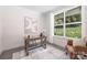Bright office space featuring a wooden desk, chair, and a large window overlooking a lush yard at 8937 Penstemons Dr, Charlotte, NC 28215