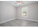 Bright bedroom with hardwood floors, a ceiling fan, and a window with a treed outdoor view at 912 Westside Dr, Newton, NC 28658