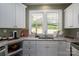 Bright kitchen with white cabinets, granite countertops, and a view of the backyard through double windows at 912 Westside Dr, Newton, NC 28658