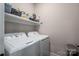Functional laundry area with a washer, dryer, and shelving for storage; clean and efficient at 912 Westside Dr, Newton, NC 28658
