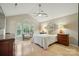 Vaulted ceiling bedroom with hardwood floors, a ceiling fan, and sunny windows with a view of the backyard at 9209 Rotherham Ln, Charlotte, NC 28216