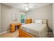 Cozy bedroom featuring a ceiling fan, light wood furniture, and natural light from the nearby window at 9209 Rotherham Ln, Charlotte, NC 28216