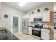 Well-lit kitchen features stainless steel appliances, white cabinets, and tiled flooring for a modern look at 9209 Rotherham Ln, Charlotte, NC 28216