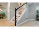 Classic staircase with wooden steps, white railings, and black accents provides an elegant transition between floors at 9209 Rotherham Ln, Charlotte, NC 28216