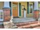 A front porch with a yellow door, green shutters, and decorative metal art at 1000 E 35Th St, Charlotte, NC 28205