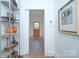 Bright hallway with shelving units, neutral walls, light hardwood floors, and transom window door, offering a modern aesthetic at 1000 E 35Th St, Charlotte, NC 28205