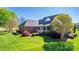 Backyard with large brick home, green lawn, and mature trees under a blue sky at 105 Snead Ct, Salisbury, NC 28144