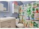 Cozy bathroom featuring a plant-themed shower curtain, vanity, shelving, and toilet at 1050 Merrywood Dr, Newton, NC 28658