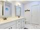 Bright bathroom boasts double sinks, white cabinets, marble floor tiles, and a new toilet at 1050 Merrywood Dr, Newton, NC 28658